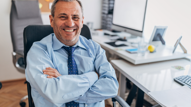 A company director happy at work after securing a favourable mortgage.
